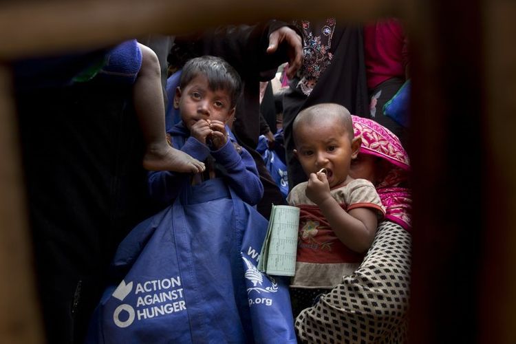 Anak-anak etnis Rohingya dan ibu mereka menunggu giliran untuk menerima paket makanan dari Program Pangan Dunia di kamp pengungsi Balukhali dekat Coxs Bazar, Bangladesh. Foto diambil pada 15 Januari 2018. (AP Photo)