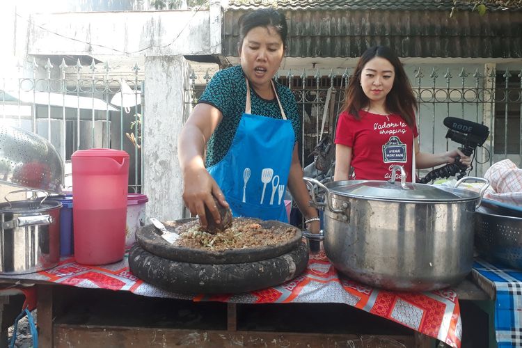 Ibu Mella, penjual rujak cingur seharga Rp 60.000 di Wiguna Timur, Kelurahan Gunung Anyar, Kecamatan Rungkut, Surabaya, melayani pembeli, Rabu (12/6/2019). 