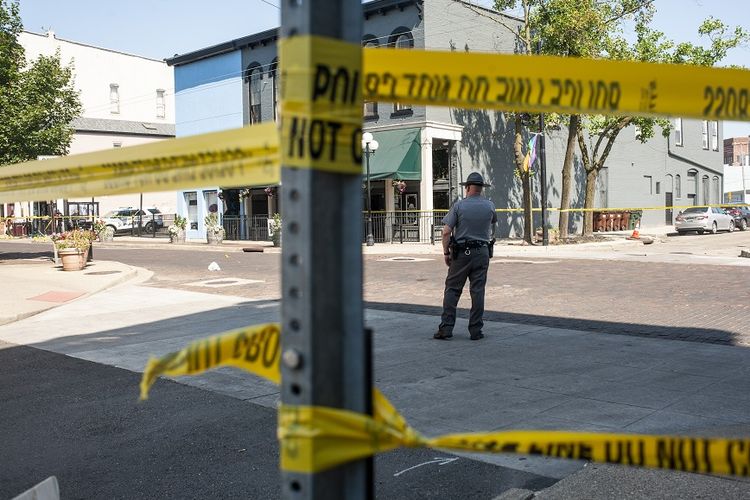 Aparat penegak hukum berjaga di sekitar lokasi penembakan massal di Dayton, Ohio, yang telah diberi garis polisi, Minggu (4/8/2019).