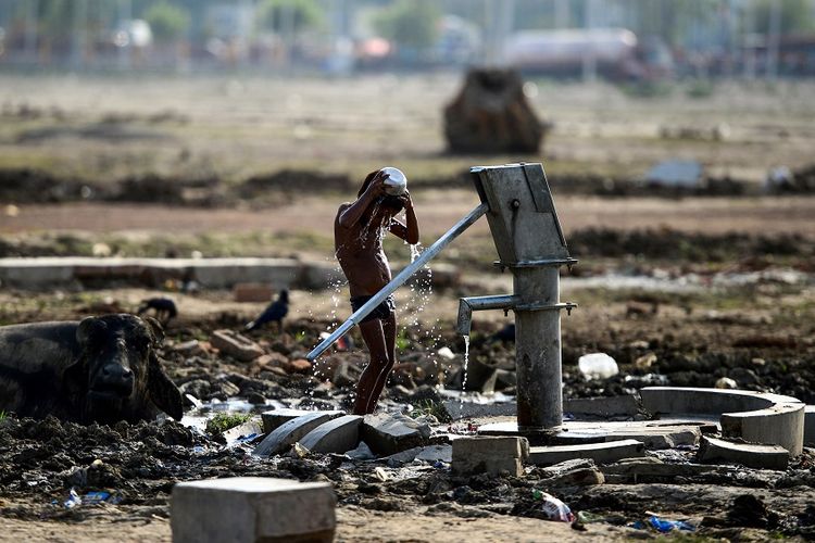 Bocah India di Allahabad menyiramkan air ke tubuhnya untuk melawan cuaca panas yang dapat mencapai lebih dari 50 derajat celcius.