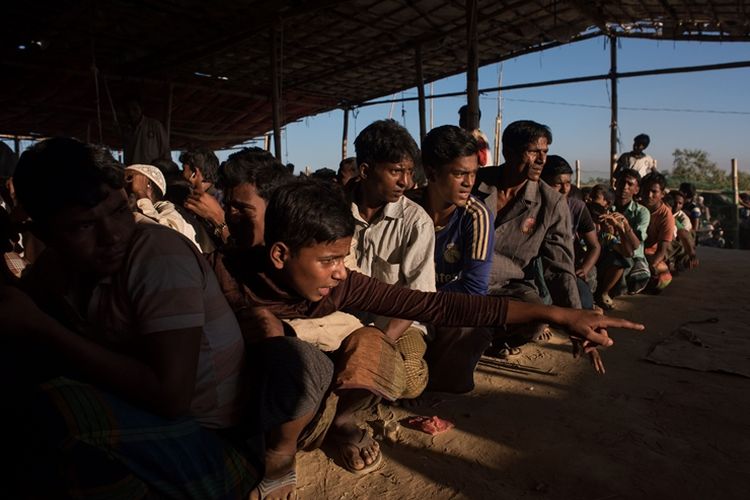 Para pengungsi Rohingya mengantre untuk mendapat bantuan makanan di kamp Kutupalong di Coxs Bazar, Bangladesh.