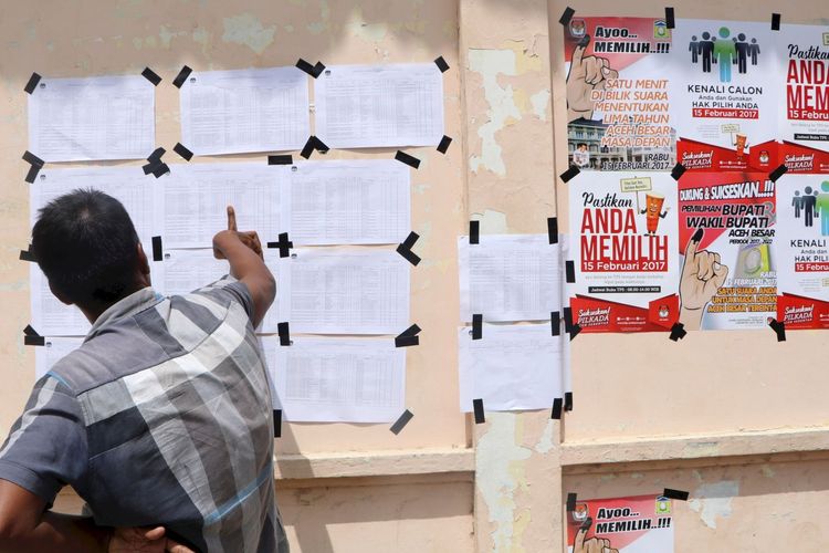 Warga Gampong Meunasah Baet, Kecamatan Krueng Barona Jaya, Aceh Besar, Aceh, melihat daftar pemilih tetap yang ditempel di tempat pemungutan suara, Senin (13/2/2017). Menjelang pemungutan suara pada Rabu (15/2/2017), warga mulai berdatangan ke tempat pemungutan suara untuk memastikan dirinya terdaftar sebagai pemilih tetap.