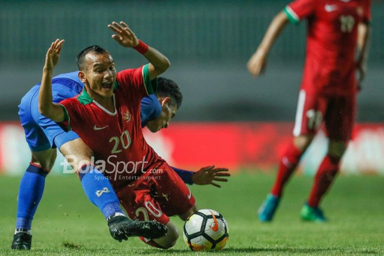 Pemain timnas U-23 Indonesia, Riko Simanjuntak, diadang pemain timnas U-23 Thailand, di Stadion Pakansari, Kabupaten Bogor, Minggu (3/6/2018).

