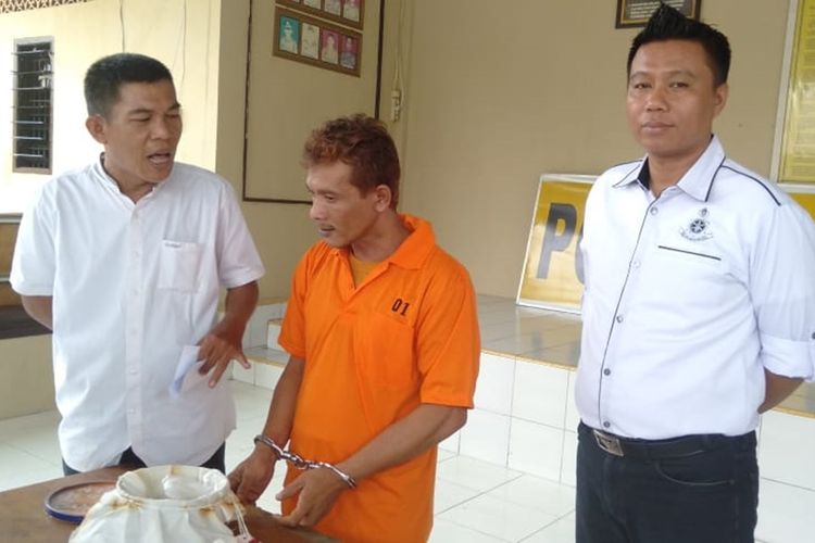 Tersangka Fitra (41) yang mengaku bisa mengubah beras menjadi emas ketika berada di Polsek Ilir Timur II Palembang, Senin (26/8/2019).