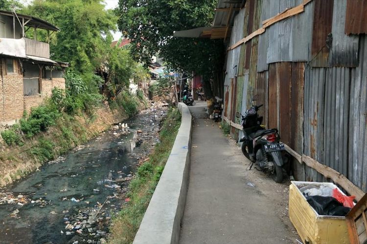 Warga tinggal berdampingan dengan Kali Tegal Amba, Jakarta Timur yang dipenuhi sampah plastik dan kemasan makanan, Selasa (9/7/2019).