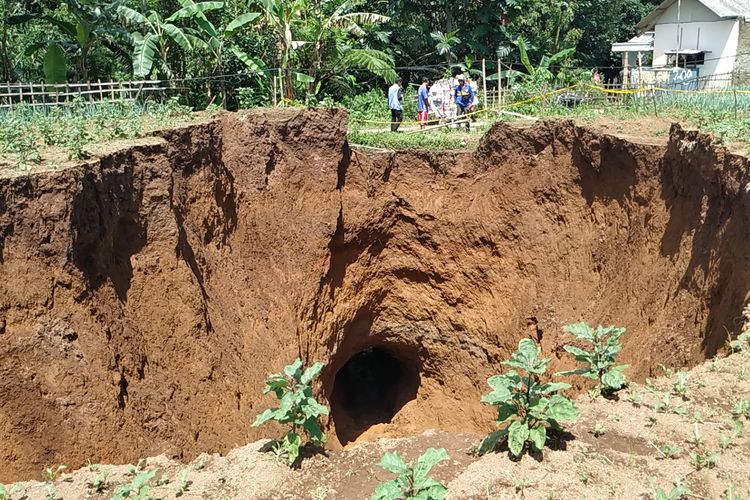 Sejumlah warga melihat tanah amblas berbentuk lubang di atas terowongan air di Desa Sukamaju, Kadudampit, Sukabumi, Jawa Barat, Senin (29/4/2019).