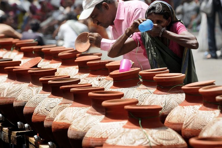 Warga India meminum air dari kendi-kendi yang disiapkan di jalanan di New Delhi di tengah cuaca panas yang menerjang negara itu dalam beberapa hari terakhir.