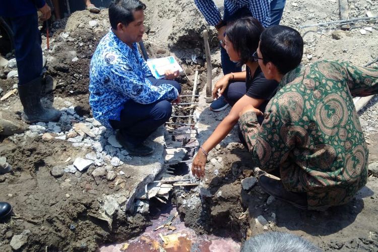 Petugas PDAM Surakarta meninjau lokasi diduga menjadi sumber air PDAM berbah merah di kawasan Jalan Adi Soemarmo, Kelurahan Banyuanyar, Banjarsari, Solo, Jawa Tengah, Rabu (17/10/2018).