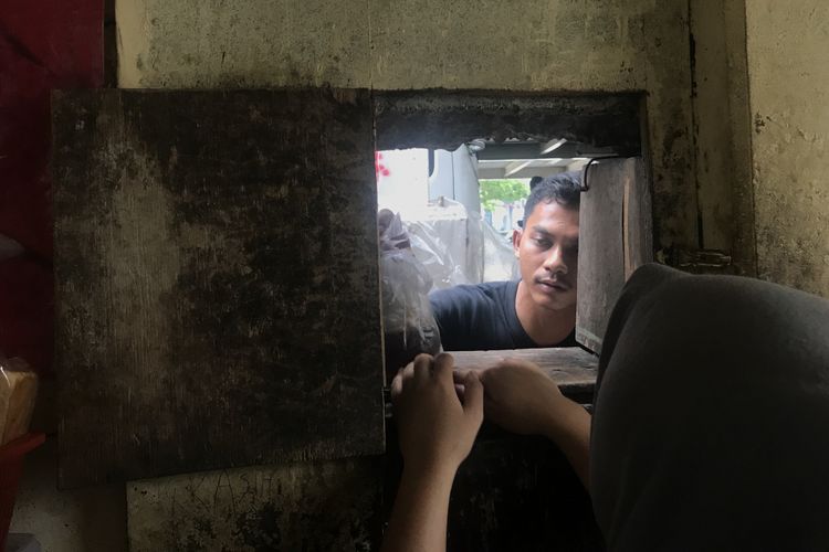 Pegawai Warung Pemalang Melayani Salah Satu Pelanggan Lewat Lubang Berukuran 30x30cm, Jumat ( 8/2/2019)