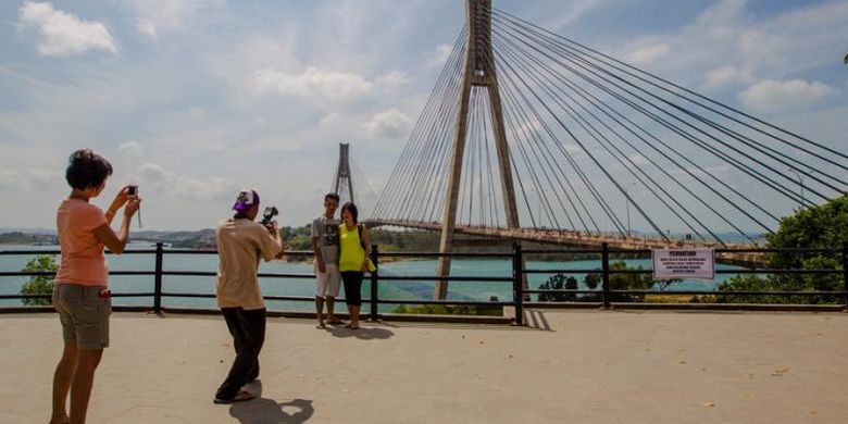 Warga berfoto dengan latar belakang pemandangan Jembatan Barelang di Batam, Kepulauan Riau, Minggu (8/2/2015). Jembatan ini merupakan satu dari enam jembatan yang dibangun untuk menghubungkan enam pulau di Batam, yaitu Pulau Batam, Pulau Tonton, Pulau Nipah, Pulau Rempang, Pulau Galang dan Pulau Galang Baru.