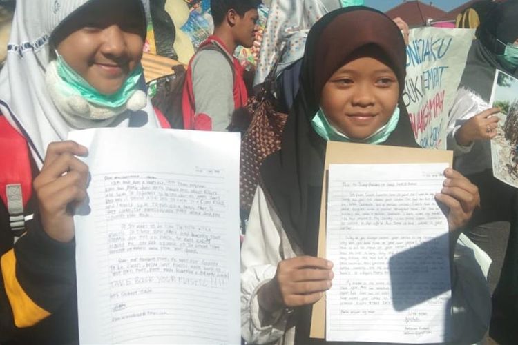 Esnina Azzahra Kirani (12) dan Hera Zaki (11) menunjukkan surat yang ia tujukan untuk Presiden Donald Trump saat menggelar demonstrasi di Kantor Konsulat Jenderal Amerika Serikat di Surabaya, Jumat (12/7/2019).