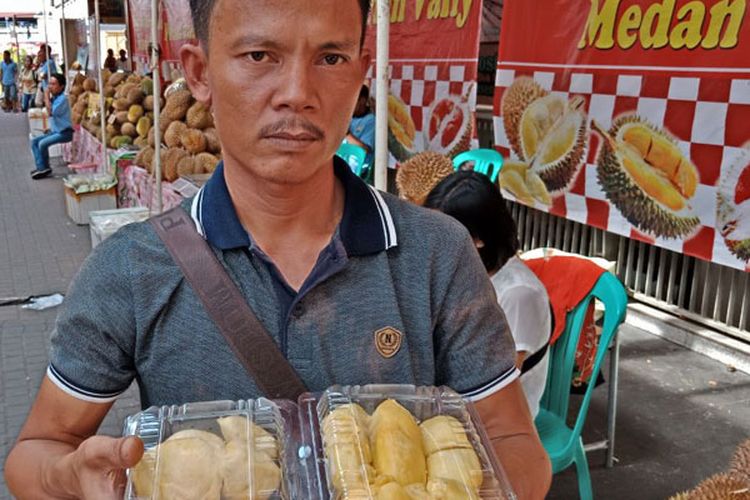 Yudi, seorang distributor durian saat membedakan durian kupas mana yang bagus untuk dibeli, di bazar durian Blok M Square, Jakarta, Rabu (7/3/2018).