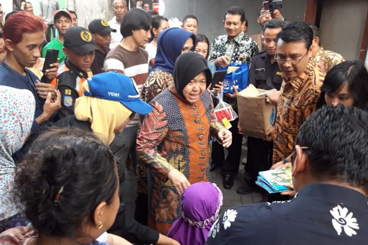 Wali Kota Surabaya, Tri Rismaharini, membagi-bagikan buku kepada sejumlah anak-anak usai melayat di rumah petugas KPPS Sunaryo yang meninggal karena kelelahan di Kelurahan Kapas Madya Barat, Kecamatan Tambaksari, Surabaya, Kamis (25/4/2019).