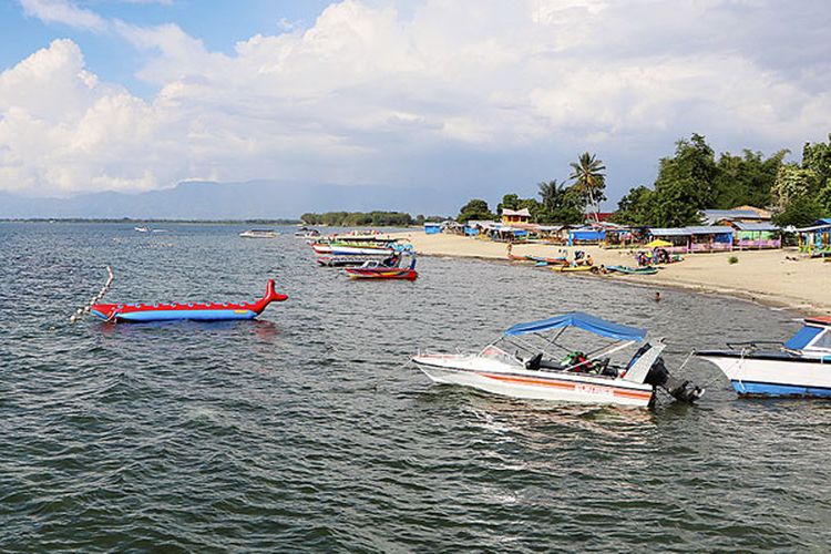 Wisatawan menikmati Danau Toba di Pantai Pasir Putih Lumban Bulbul, Kecamatan Balige, Kabupaten Toba Samosir, Sumatera Utara, Jumat (9/6/2017).