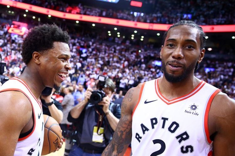 Kawhi Leonard dan Kyle Lowry merayakan kemenangan Toronto Raptors atas Philadelphia 76ers di  Scotiabank Arena pada semifinal Wilayah Timur NBA, 12 Mei 2019. 