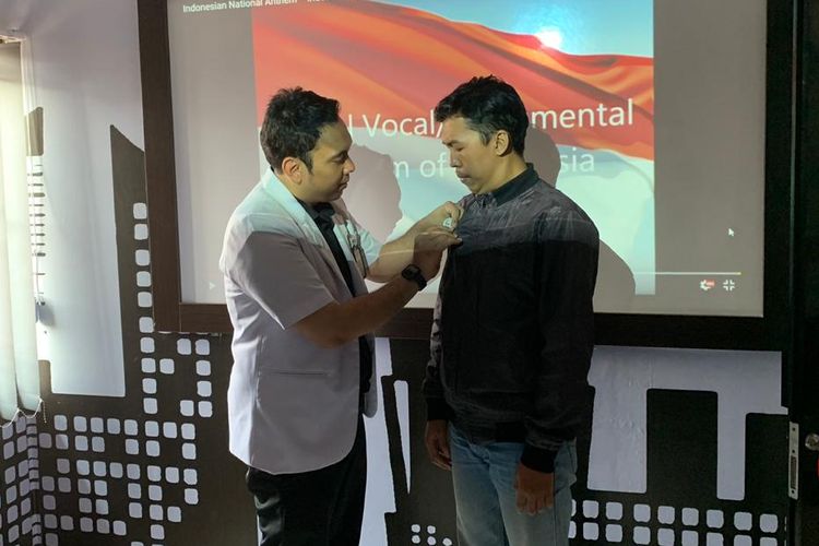 Dokter Yusuf Nugraha menyematkan pin merah putih kepada pasien yang usai menyanyikan lagu Indonesia Raya dan membaca Pancasila sebelum berobat gratis di Klinik Harapan Sehat, Cianjur, Jawa Barat
