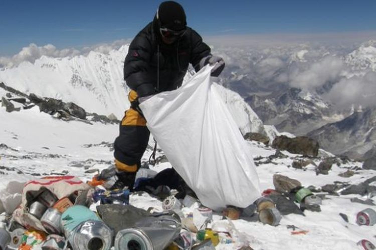 Dalam foto yang diambil pada 23 Mei 2010 ini, seorang sherpa asal Nepal sedang membersihkan sampah yang ditinggalkan para pendaki Gunung Everest di ketinggian 8.000 meter di atas permukaan laut. Mulai April mendatang, pemerintah Nepal mengharuskan tiap pendaki membawa turun setidaknya delapan kilogram sampah dari puncak gunung itu.