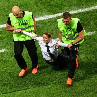 Anggota kelompok Pussy Riot, diaman oleh petugas keamanan pada pertandingan final Piala Dunia 2018  di Stadion Luzhniki di Moskwa, Rusia, Minggu (25/7/2018). (AFP/Mladen Antonov)