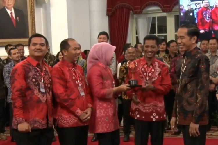 Presiden Joko Widodo menyerahkan piala ke pemenang festival Gapura Cinta Negeri. Festival ini digelar dalam rangka bulan kemerdekaan.   Para pemenang diundang ke Istana untuk dapat bertemu dan mendapat hadiah langsung dari Presiden Jokowi, Senin (2/9/2019). 