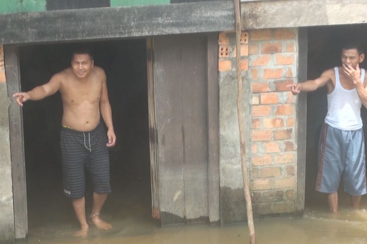 Warga Kelurahan Payu Putat memperlihatkan bagian bawah rumah mereka yang mulai terendam banjir akibat luapan sungai lematang dan curah hujan yang turun cukup tinggi beberapa hari ini. 