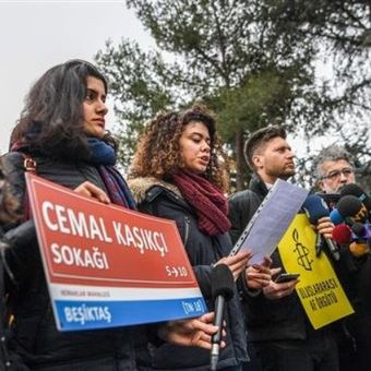 Seorang perempuan memegang papan Jalan Jamal Khashoggi ketika Amnesty internasional berkumpul di depan konsulat Arab Saudi di Istanbul, Turki, Kamis (10/1/2019). (AFP/OZAN KOSE).