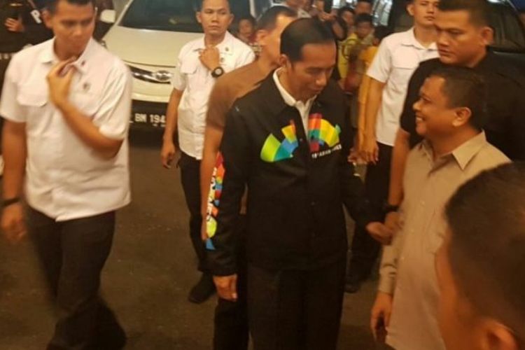 Presiden Ri Joko Widodo bercengkerama dengan warga saat berkunjung ke Pekanbaru, Riau. Jokowi tampak kenakan jaket Asian Games berwarna hitam. 