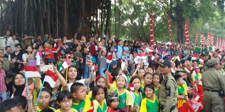 Anak-anak sekolah dan masyarakat Kota Solo menunggu datangnya pawai obor Asian Games 2018 di Jalan Jenderal Sudirman, Solo, Kamis (19/7/2018) siang.