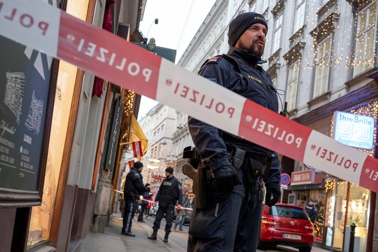Petugas kepolisian Austria berjaga di dekat lokasi penembakan yang telah ditutup oleh garis polisi di Wina, Jumat (21/12/2018).