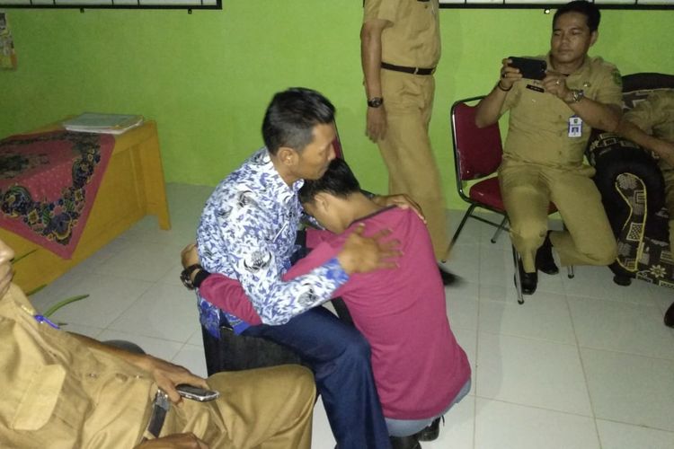 A (19) siswa SMA Negeri 2 Rakit Kulim di Kabupaten Inhu, Riau, memeluk dan meminta maaf kepada kepala sekolahnya, Bambang Fajrianto (49) yang dipukulinya, usai proses mediasi, Senin (18/3/2019).