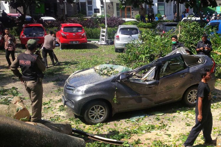 Petugas mengevakuasi salah satu mobil yang tertimpa pohon tumbang di RSUD Syamsudin Kota Sukabumi, Jawa Barat, Kamis (26/4/2018). 