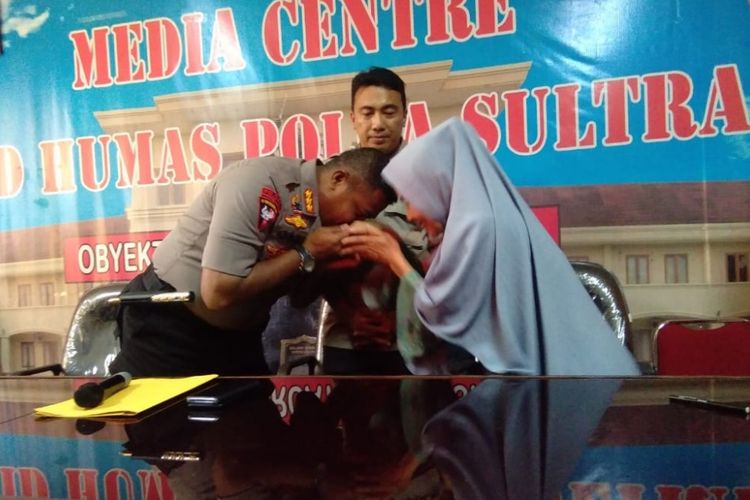 Dansat Brimob Polda Sultra, Kombel Pol Joni Afrizal Syarifuddin, mencium tangan Yuda Husna sebagai permintaan maaf atas aksi anggotanya yang telah merusak rumahnya. (KOMPAS.com/ KIKI ANDI PATI)