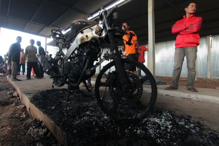 Warga berdiri di dekat sepeda motor yang terbakar akibat ledakan dan kebakaran di pabrik kembang api di kompleks Pergudangan 99, Kosambi, Kabupaten Tangerang, Banten, Kamis (26/10/2017). Lebih dari 40 orang tewas dalam kejadian tersebut.