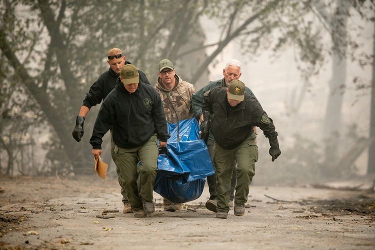 Deputi dari Kantor Sheriff Yuba County membawa kantong jenazah korban kebakaran hutan di Paradise, California, pada Sabtu (10/11/2018).