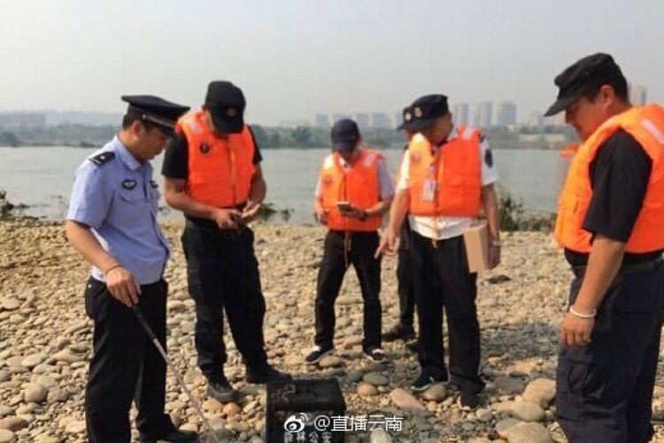 Polisi dan dinas perikanan di Jinghong, China, berkumpul di depan kotak berisi ular yang mereka tangkap. Ular itu dilepaskan seorang pengusaha properti sebagai doa untuk nasib baik.