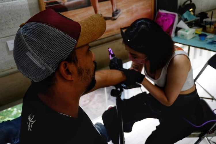 Nita, salah satu tattoo artist tengah menato pengunjung dalam acara flash tattoo di pameran CIN(TA)TTOOKEPADAKU (Cintaku Kepadaku).
