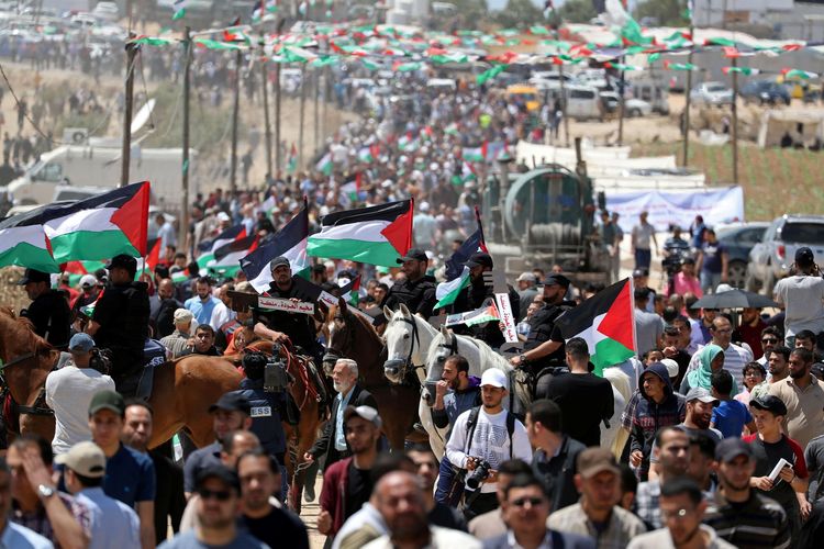 Warga Palestina berkumpul saat aksi protes memperingati 71 tahun Nakba, atau malapetaka, ketika ratusan ribu mereka dipaksa meninggalkan rumah di tengah perang yang mengelilingi kemerdekaan Israel pada 1948, dekat perbatasan Israel-Gaza, bagian timur Kota Gaza, Rabu (15/5/2019).
