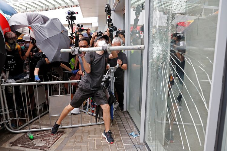 Pengunjuk rasa berusaha masuk secara paksa ke gedung Dewan Legislatif dimana polisi huru-hara terlihat, saat peringatan penyerahan Hong Kong ke China di Hong Kong, China, Senin (1/7/2019).