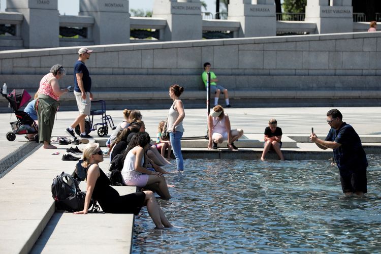 Turis mendinginkan diri di kolam selama suhu panas di Washington, Amerika Serikat, pada 27 Juni 2019.