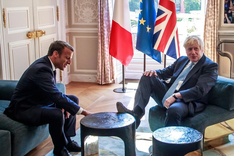 Perdana Menteri Inggris Boris Johnson (kanan) ketika menumpangkan kaki di meja di depan Presiden Perancis Emmanuel Macron dalam pertemuan di Paris 22 Agustus 2019.