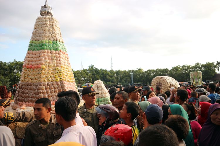 Ratusan warga mengelilingi tumpeng besar berisi ribuan butir kue apem di alun-alun Jombang Jawa Timur, Jumat (3/5/2019) petang. Menyambut Ramadhan, Pemkab Jombang setiap tahun menggelar kegiatan gerebek apem, sebagai penanda dan pengingat datangnya bulan ramadhan.                     