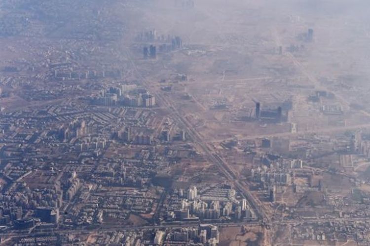 Foto yang diambil pada 2014 ini memperlihatkan asap tebal akibat polusi menutupi kota New Delhi, India.