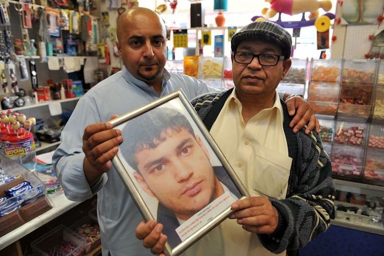 Mumtaz Khan (kanan) bersama putranya Mohd (kiri) memegang foto mendiang putranya, Juniad, yang tewas dibunuh.
