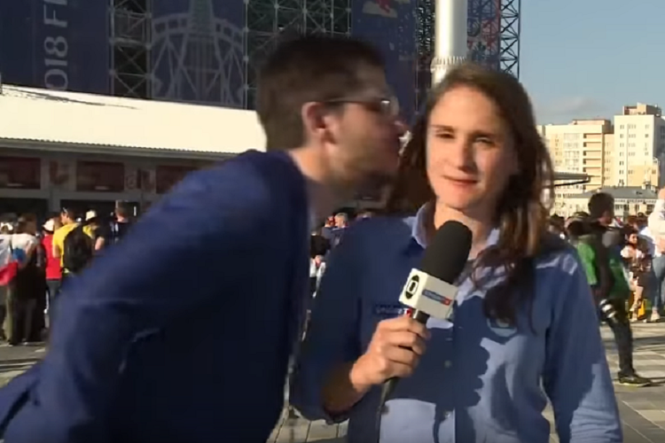 Jurnalis asal Brasil, Julia Guimaraes, ketika berusaha dicium oleh seorang fans ketika melaporkan pertandingan Senegal versus Jepang di Yekaterinburg Minggu (24/6/2018).