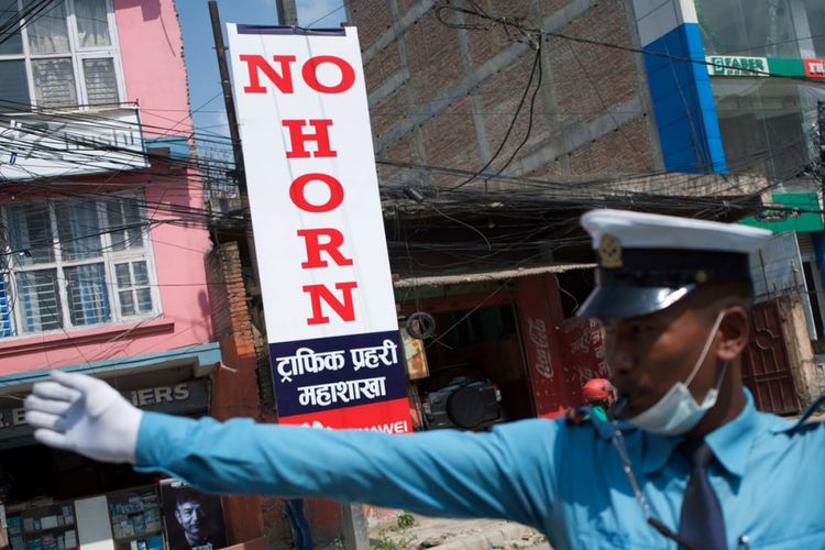Petugas mengatur lalu lintas di Kathmandu, Nepal. Kota tersebut telah melarang penggunaan klakson kendaraan sejak April 2017 lalu.