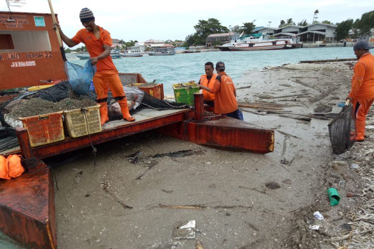 Petugas membersihkan kerikil yang berasal dari Gunung Anak Krakatau di Pulau Harapan, Kepulauan Seribu, Kamis (27/12/2018).