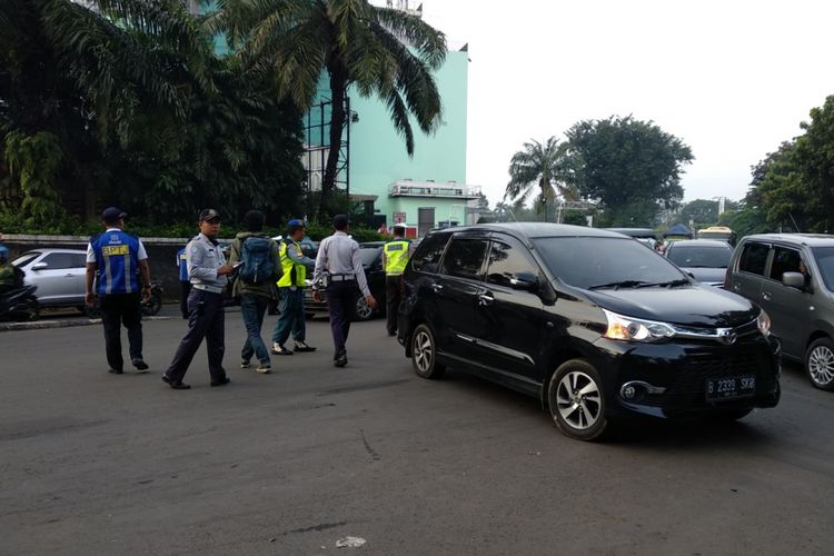 Suasana gerbang tol Cibubur saat pelaksanaan uji coba ganjil genap hari pertama, Senin (16/4/2018)