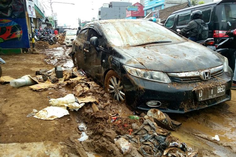 Sebuah kendaraan roda empat terlihat kotor dengan lumpur dan sampah di pinggirannya. Itu merupakan salah satu kendaraan yang sudah dievakuasi setelah sebelumnya bertumpuk terbawa arus banjir yang masuk ke gudang furnitur di Jalan AH Nasution, Kelurahan Cicaheum, Kecamatan Kiaracondong.