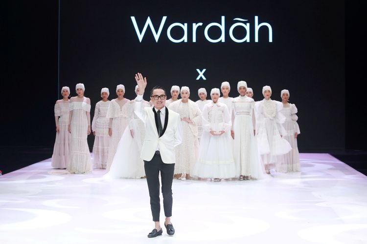 Desainer Barli Asmara bersama busana rancangannya di Indonesia Fashion Week 2019.
