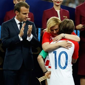 Pemain tim sepak bola Kroasia Luka Modric mendapat pelukan dari Presiden Kroasia Kolinda Grabar-Kitarovic di Piala Dunia 2018 Rusia di Stadion Luzhniki, di Moskwa, Minggu (15/7/2018). (AFP/Odd Andersen)