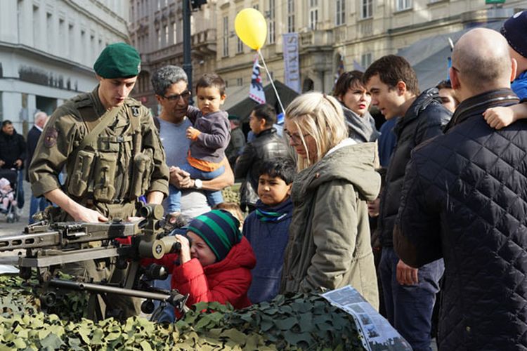 Personel militer berinteraksi dengan pengunjung anak-anak pada peringatan Hari Nasional Austria, Jumat (26/10/2018).